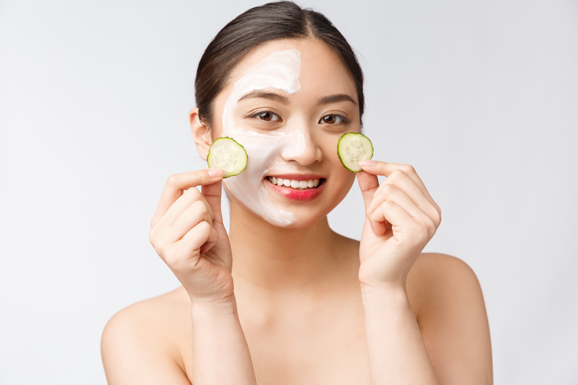 Beauty young asian women skin care image with cucumber on white background studio